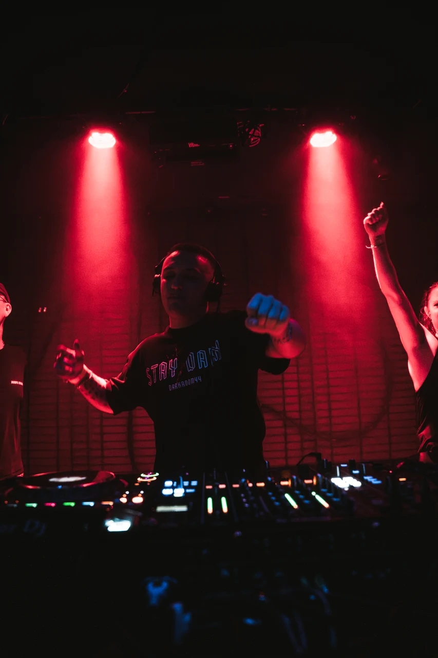 DJ und Publikum bei 0711 Raves unter roten Scheinwerfern